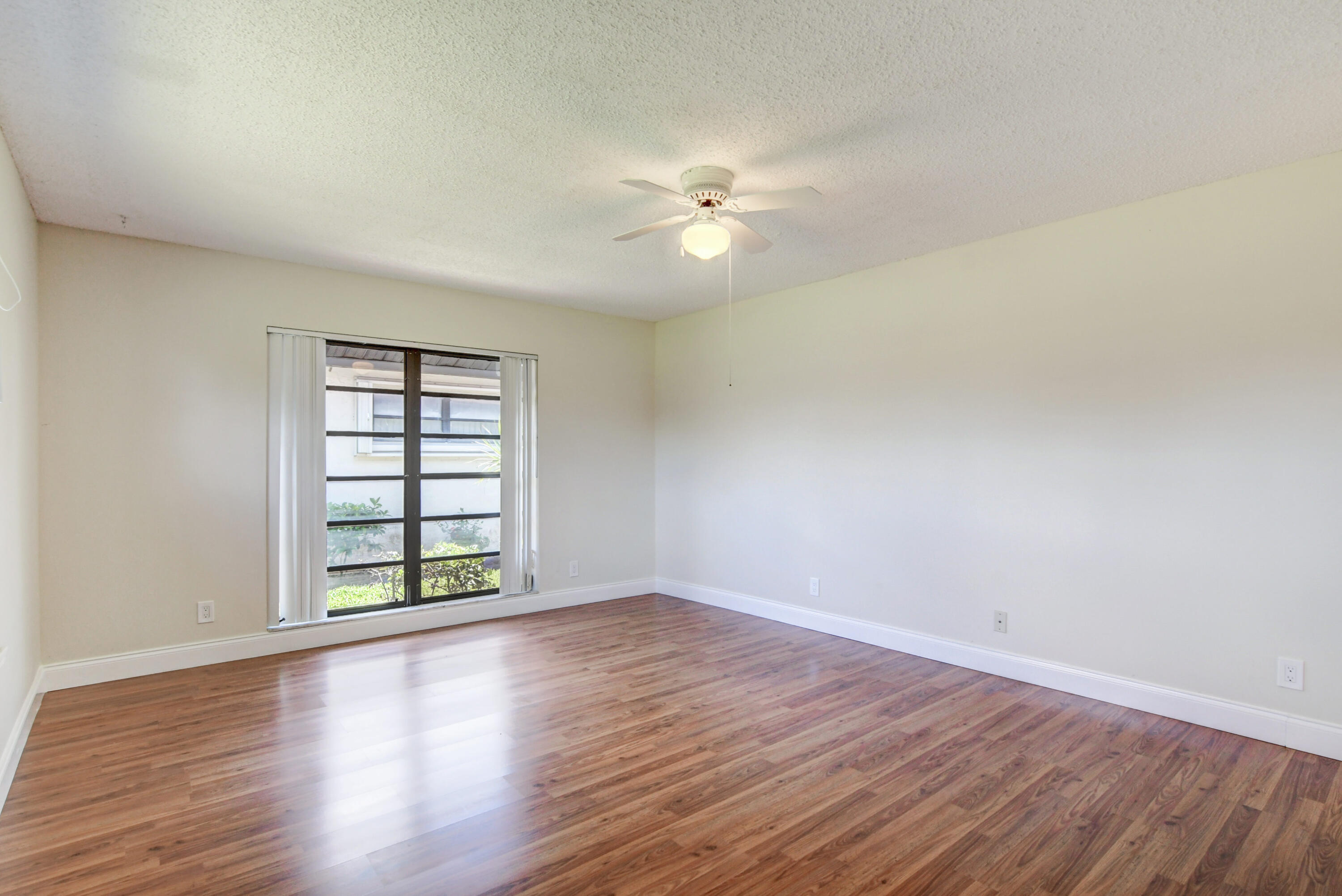 4867 Hawkwood Road, Unit B Boynton Beach, FL 33436 - Photo 20 of 37 a view of an empty room with window and wooden floor