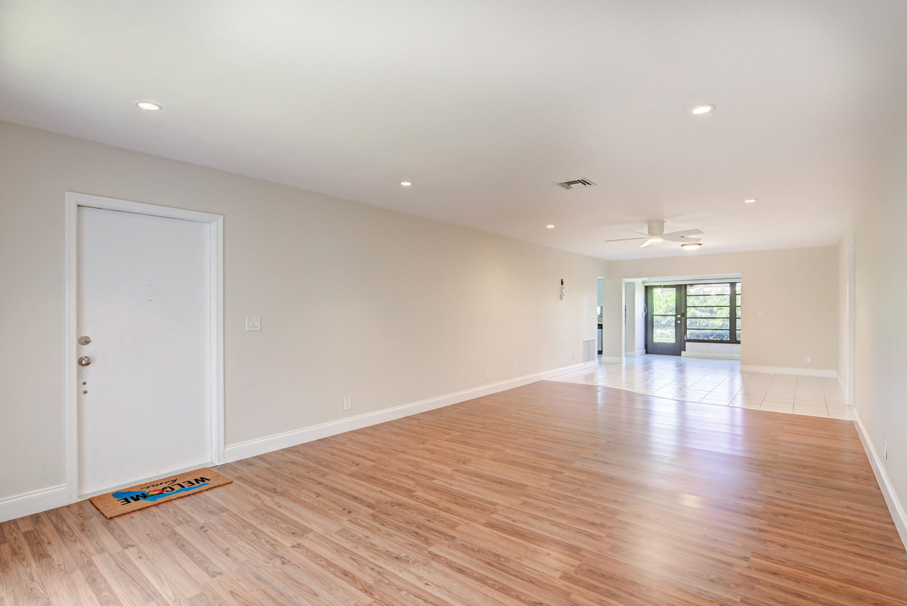 4867 Hawkwood Road, Unit B Boynton Beach, FL 33436 - Photo 2 of 37 a view of an empty room with wooden floor and a window