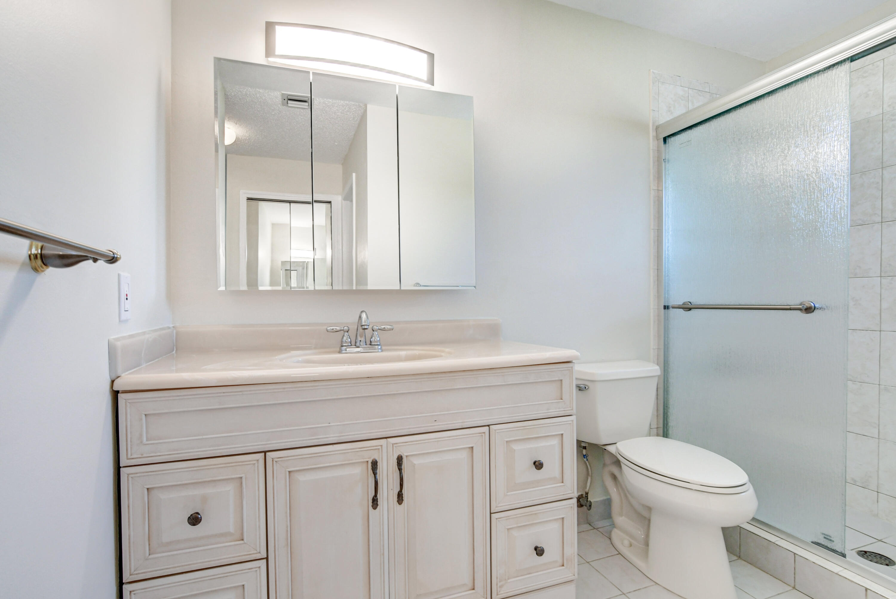 4867 Hawkwood Road, Unit B Boynton Beach, FL 33436 - Photo 21 of 37 a bathroom with a granite countertop sink a toilet and a mirror