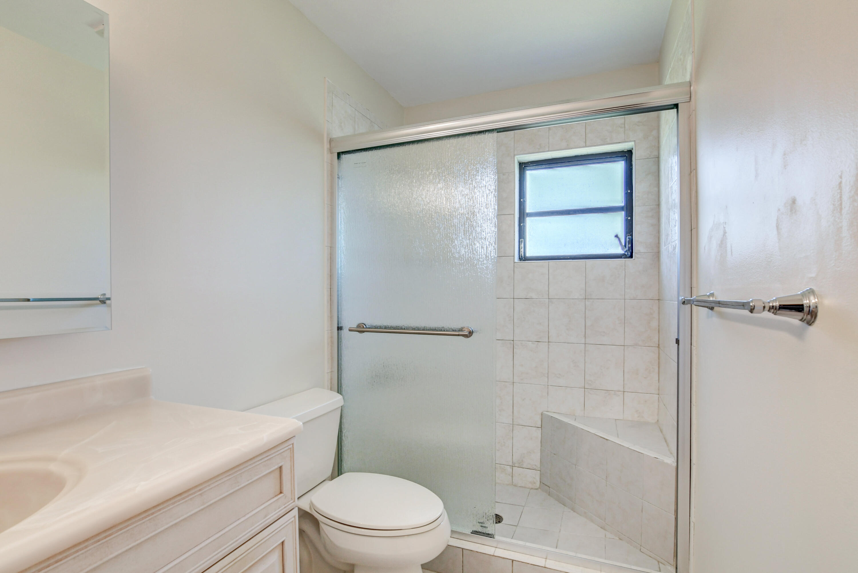 4867 Hawkwood Road, Unit B Boynton Beach, FL 33436 - Photo 22 of 37 a bathroom with a shower a toilet and sink