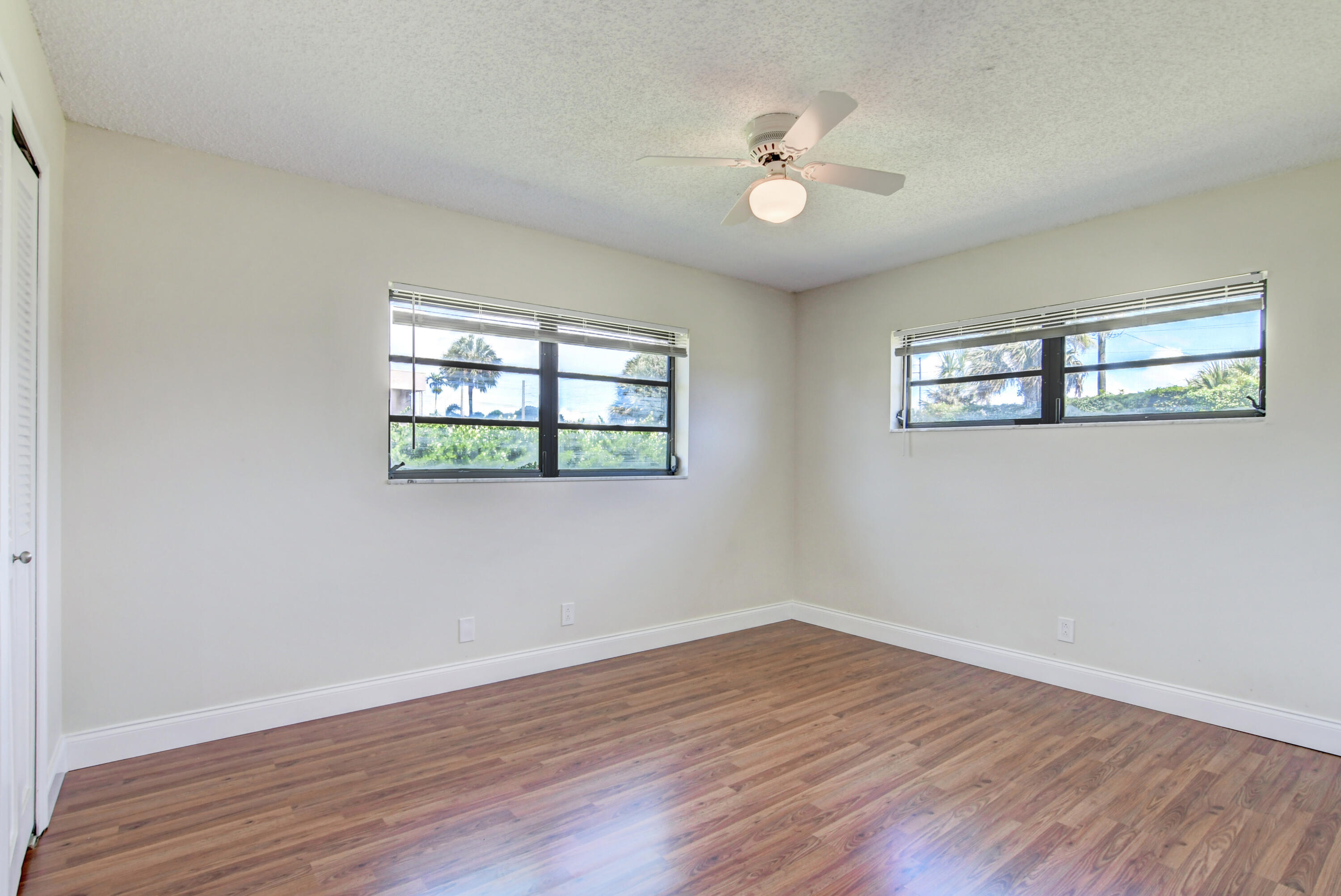 4867 Hawkwood Road, Unit B Boynton Beach, FL 33436 - Photo 24 of 37 a view of empty room with wooden floor and fan