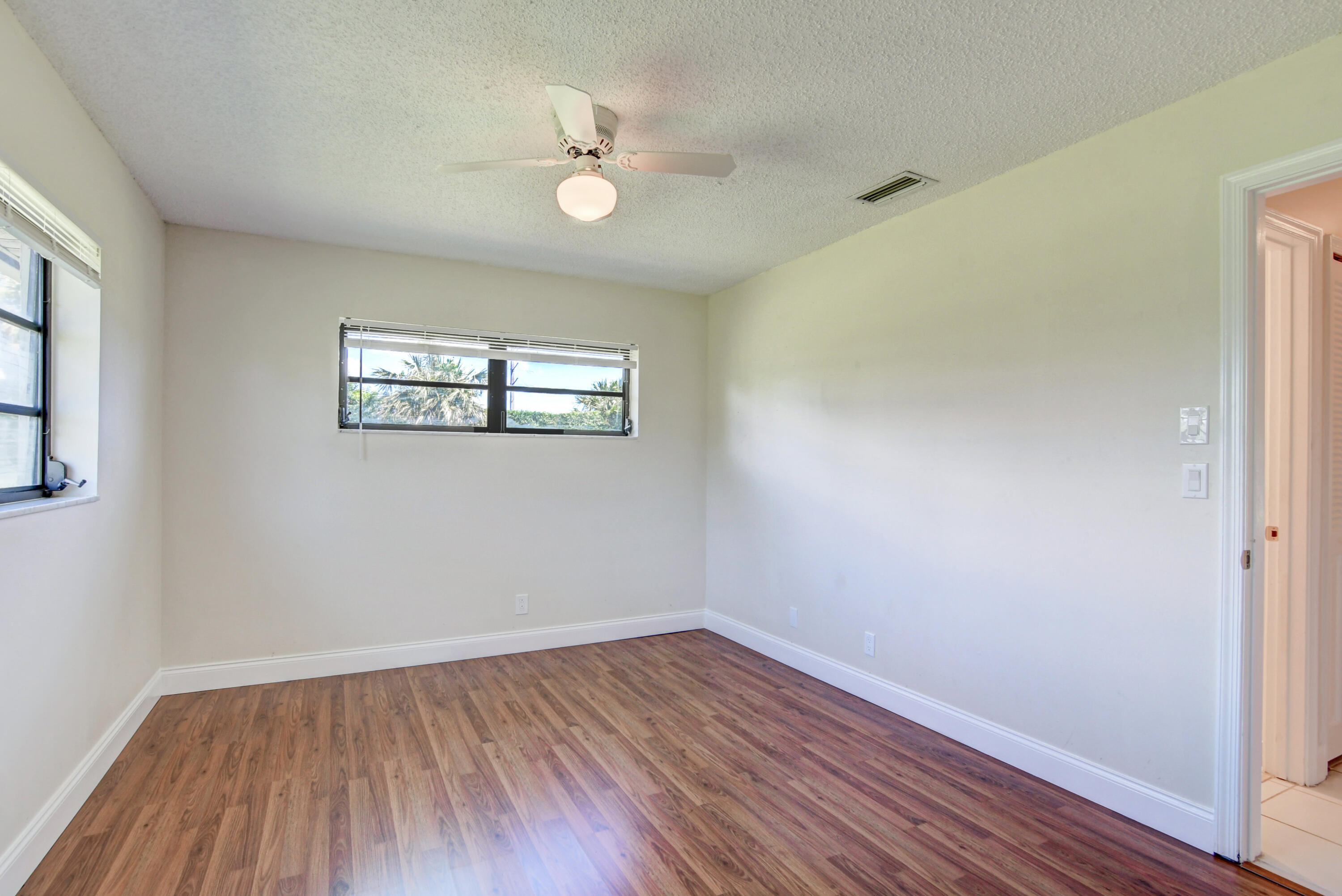 4867 Hawkwood Road, Unit B Boynton Beach, FL 33436 - Photo 25 of 37 wooden floor in an empty room with a window