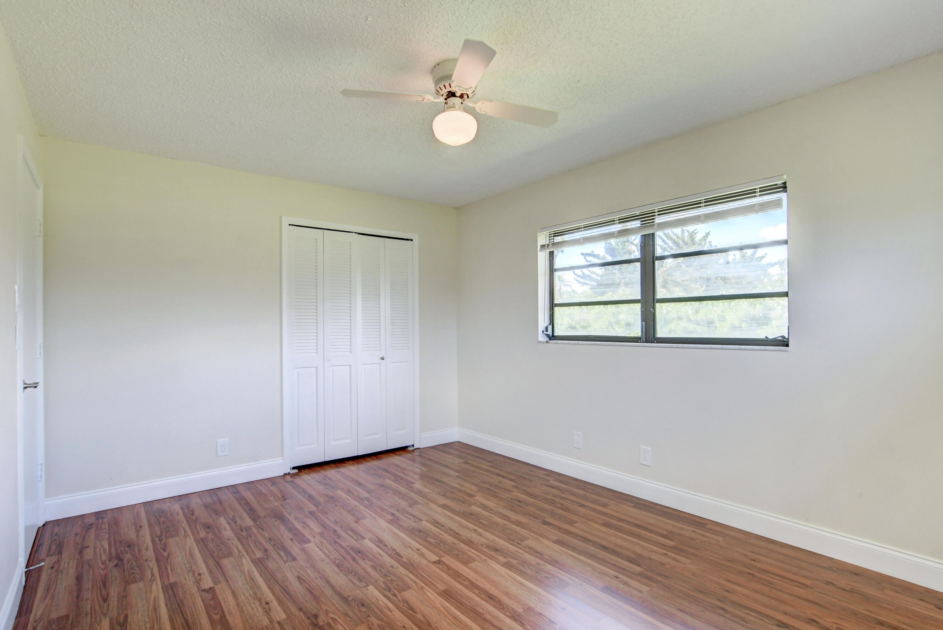 4867 Hawkwood Road, Unit B Boynton Beach, FL 33436 - Photo 27 of 37 an empty room with wooden floor and windows