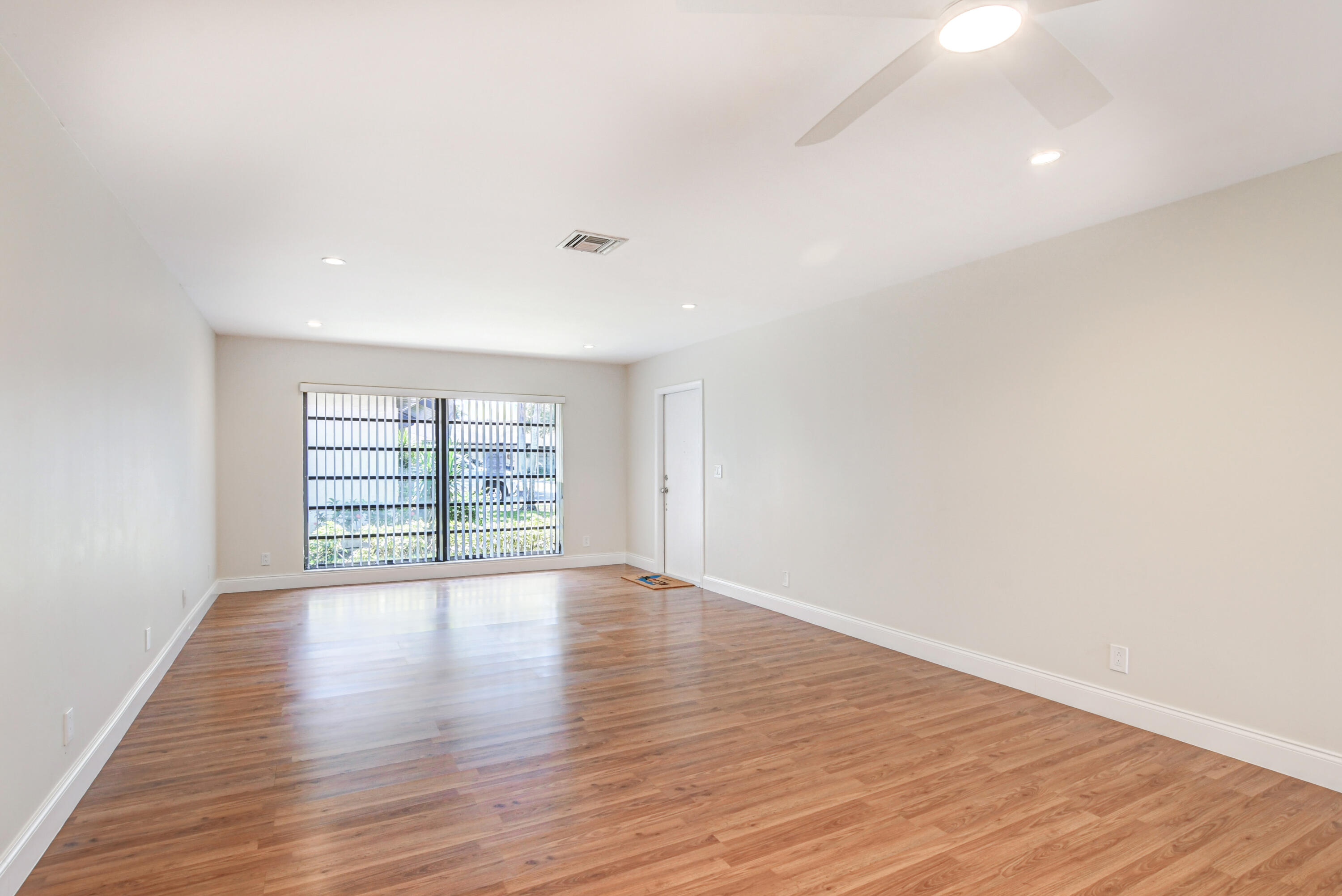 4867 Hawkwood Road, Unit B Boynton Beach, FL 33436 - Photo 3 of 37 a view of an empty room with wooden floor and a window