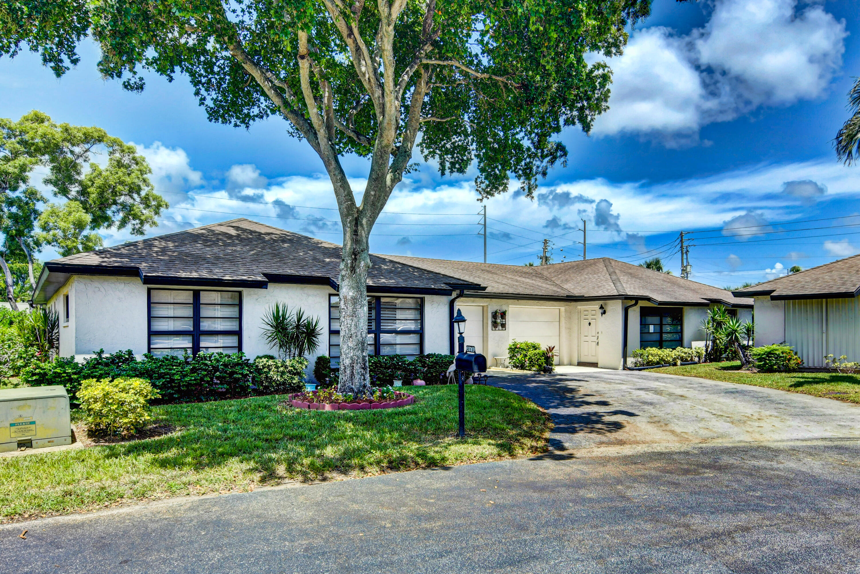 4867 Hawkwood Road, Unit B Boynton Beach, FL 33436 - Photo 32 of 37 a front view of a house with a yard and potted plants