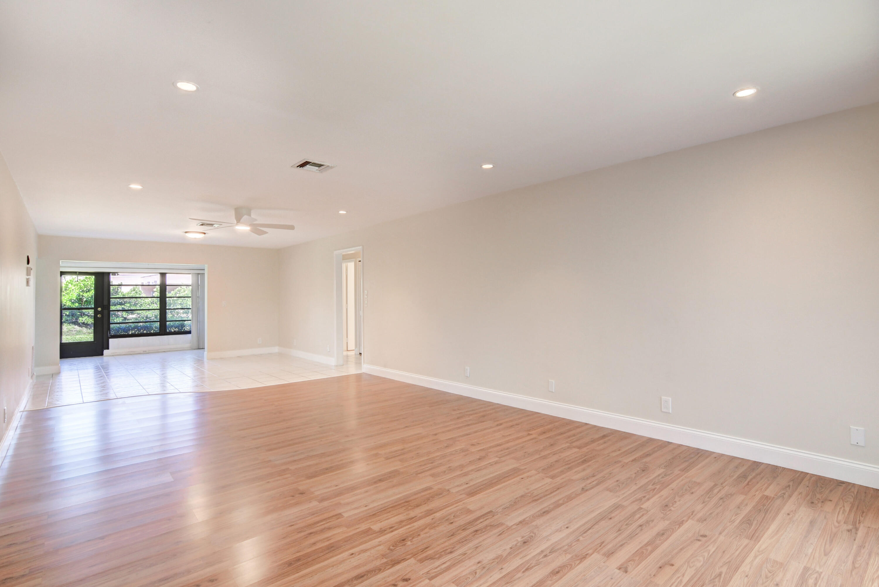 4867 Hawkwood Road, Unit B Boynton Beach, FL 33436 - Photo 4 of 37 a view of an empty room with wooden floor and a window