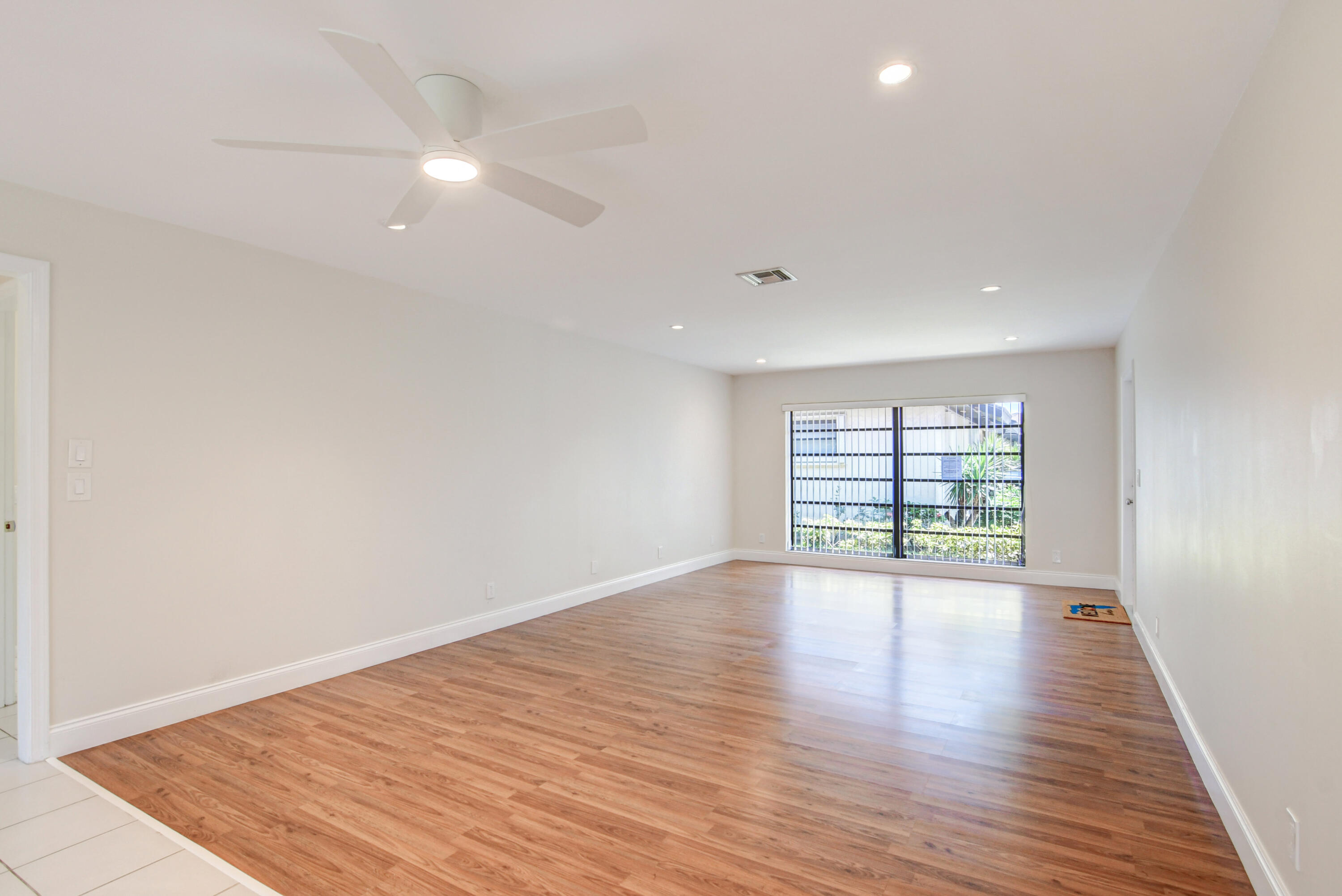 4867 Hawkwood Road, Unit B Boynton Beach, FL 33436 - Photo 5 of 37 an empty room with wooden floor and windows