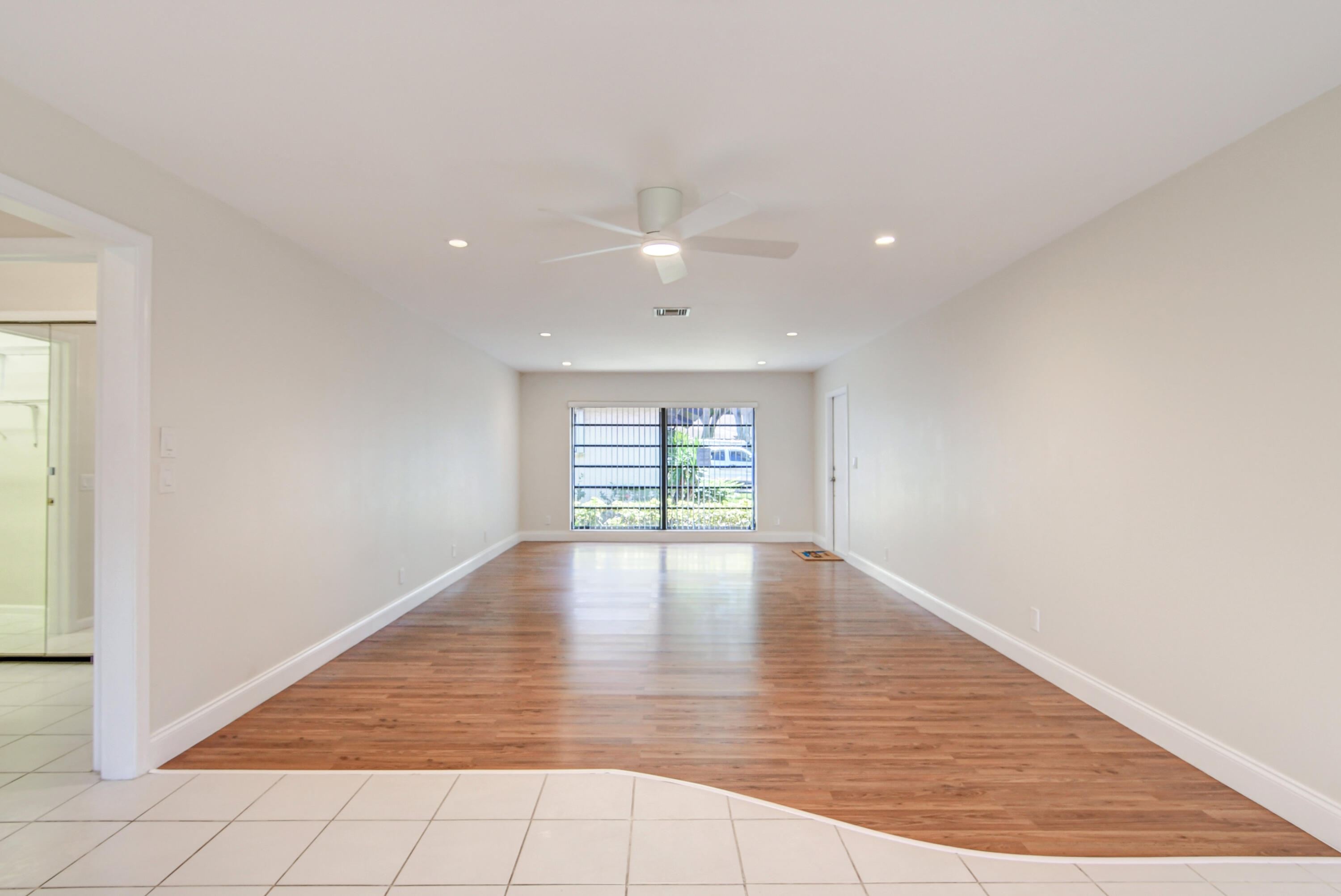 4867 Hawkwood Road, Unit B Boynton Beach, FL 33436 - Photo 6 of 37 an empty room with wooden floor and windows
