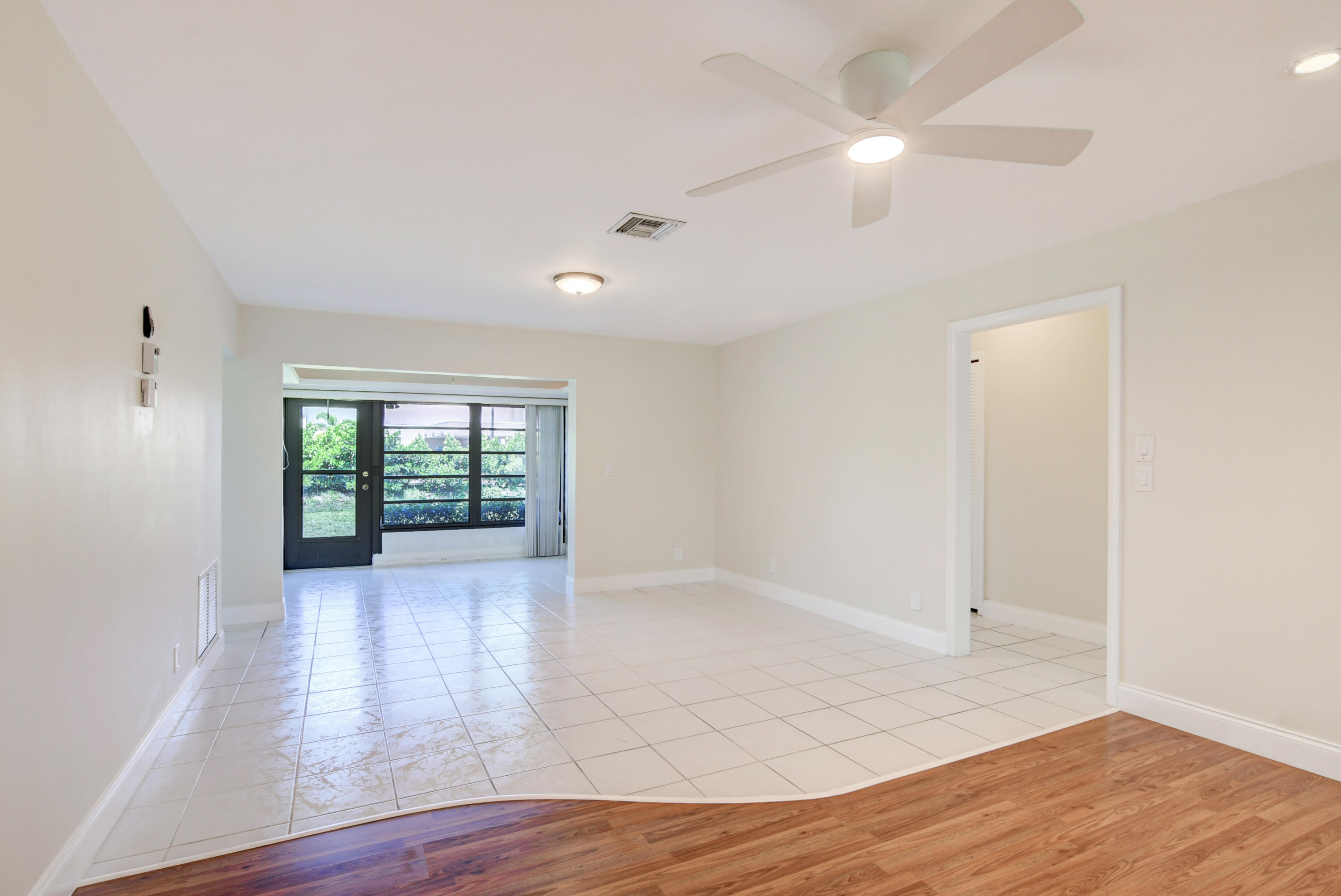 4867 Hawkwood Road, Unit B Boynton Beach, FL 33436 - Photo 7 of 37 an empty room with wooden floor and windows