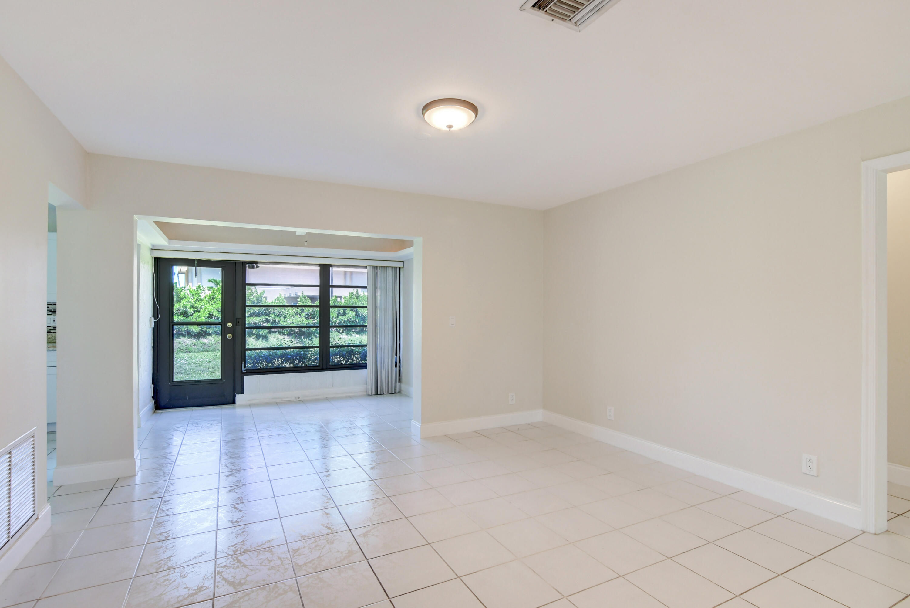 4867 Hawkwood Road, Unit B Boynton Beach, FL 33436 - Photo 8 of 37 wooden floor in an empty room with a window