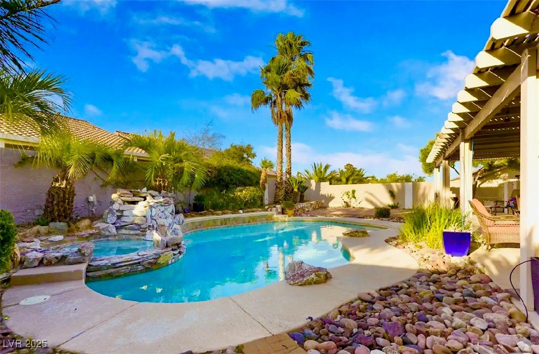 8928 Rusty Rifle Avenue Las Vegas, NV 89143 - Photo 20 of 23 Shimmering pool and spa framed by tall palm trees,