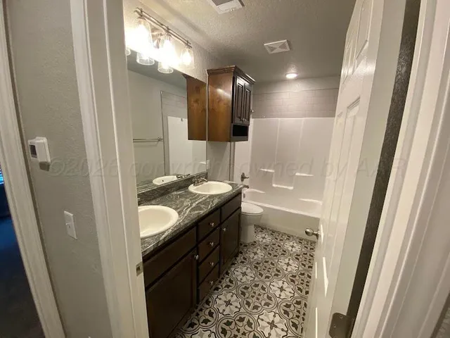 a bathroom with a granite countertop sink a mirror and a shower