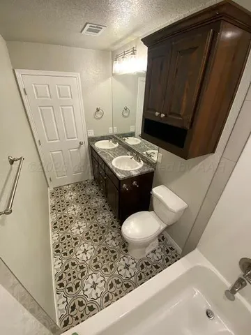 a bathroom with a sink a toilet and shower curtain