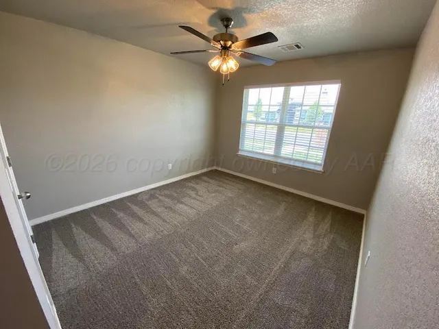 an empty room with a window and a fan