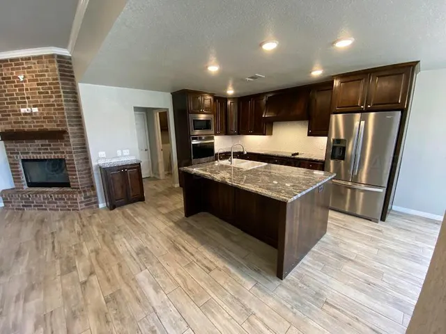 a kitchen with stainless steel appliances granite countertop a stove and a refrigerator