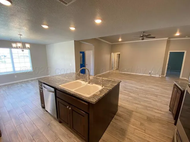 a kitchen with stainless steel appliances granite countertop a sink stove and wooden floor