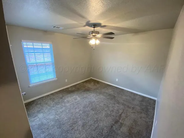 en empty room with windows and ceiling fan