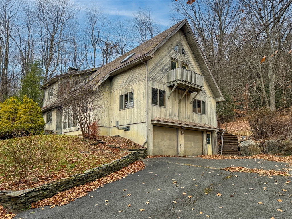 a view of a white house with a large tree
