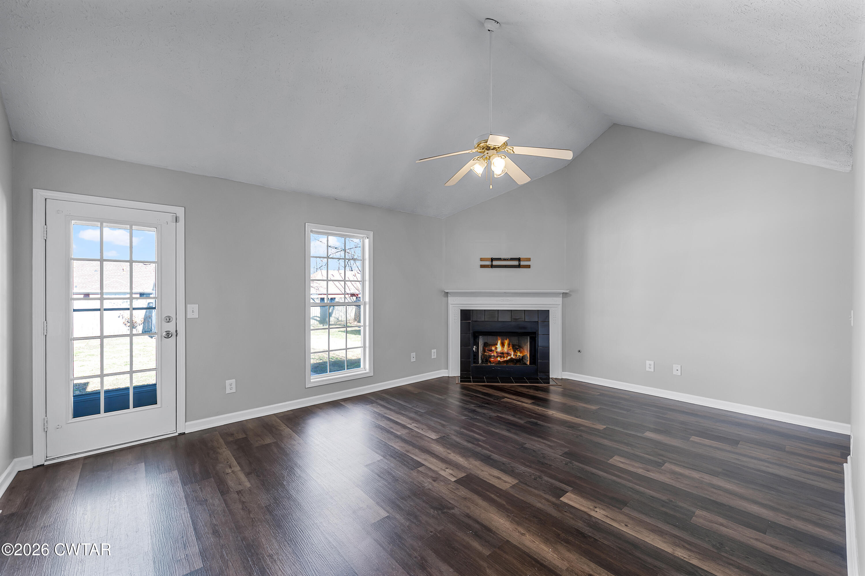 75 Suncrest Drive Jackson, TN 38305 - Photo 4 of 24 an empty room with wooden floor fireplace and windows