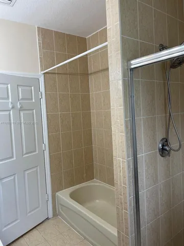 a view of bathroom with a shower and closet