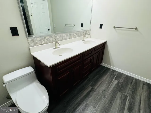 a bathroom with a sink toilet and mirror