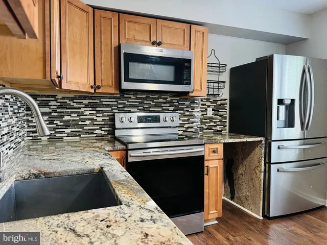 a kitchen with granite countertop a stove and a microwave