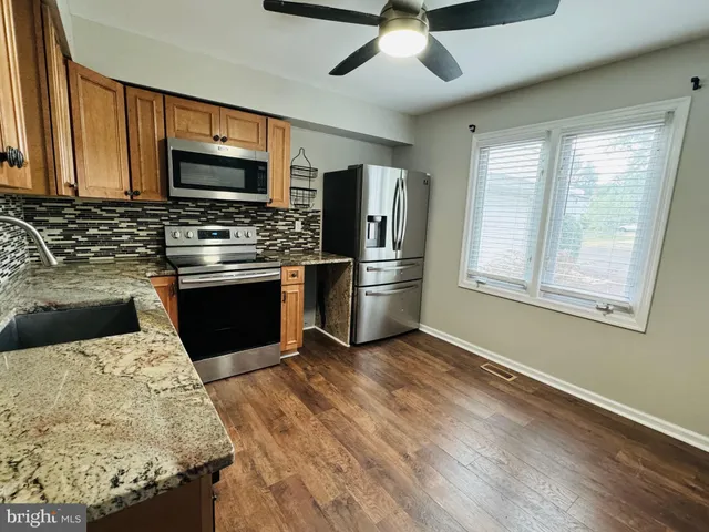 a kitchen with stainless steel appliances granite countertop a stove sink microwave and refrigerator