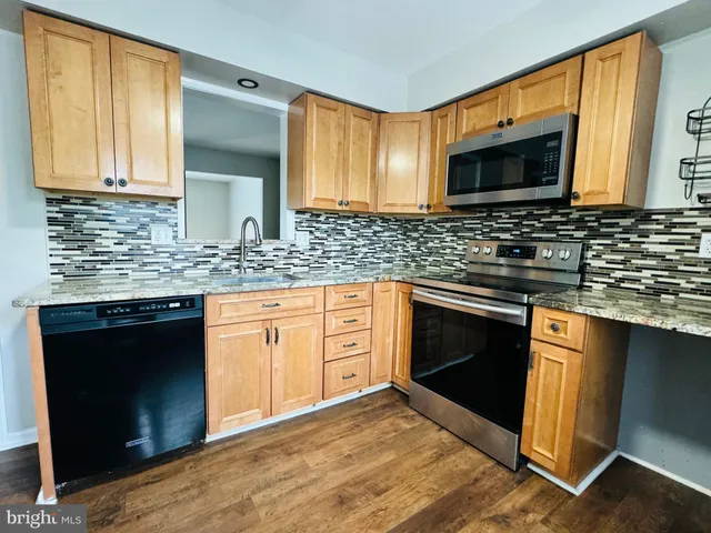 a kitchen with stainless steel appliances granite countertop a stove microwave and sink