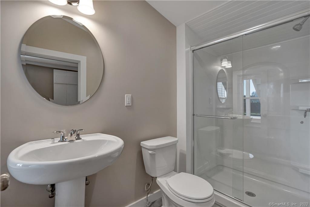 368 Boston Street Guilford, CT 06437 - Photo 5 of 24 a bathroom with a toilet sink and mirror