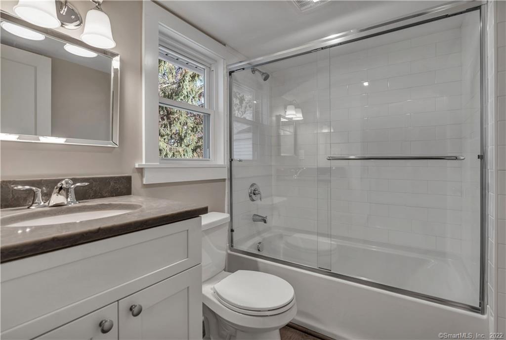 368 Boston Street Guilford, CT 06437 - Photo 7 of 24 a bathroom with a granite countertop sink a toilet and shower