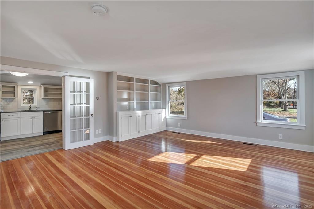 368 Boston Street Guilford, CT 06437 - Photo 8 of 24 a view of empty room with wooden floor and kitchen view