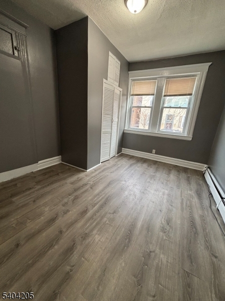 108 Pine Street, Unit 1 Montclair, NJ 07042 - Photo 2 of 9 an empty room with wooden floor and windows