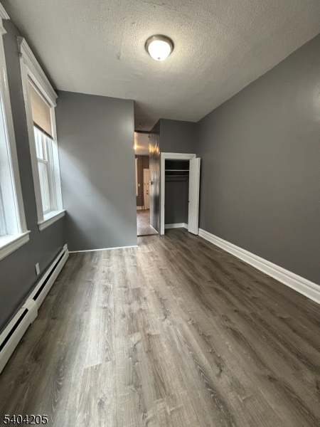 108 Pine Street, Unit 1 Montclair, NJ 07042 - Photo 5 of 9 an empty room with wooden floor and windows