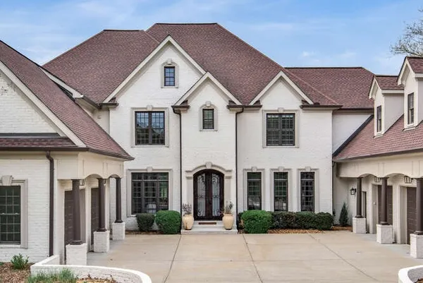 a view of a house with large windows and a pathway
