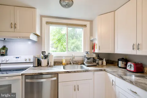 a kitchen with appliances a sink and cabinets