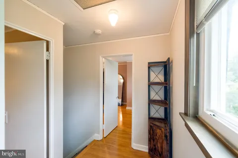 a view of a hallway with wooden floor and staircase