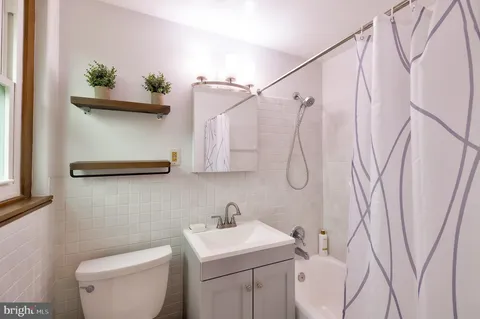 a bathroom with a sink a toilet and a shower curtain