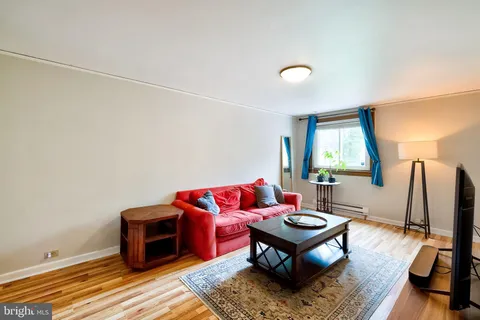 a living room with furniture a flat screen tv and a window