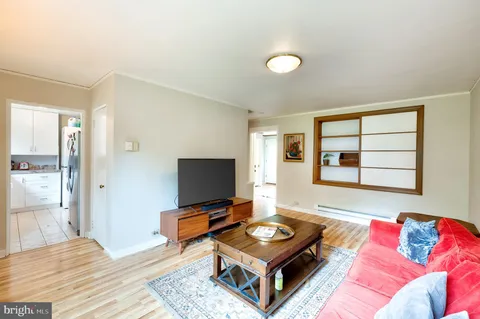 a living room with a bed furniture and next to a window