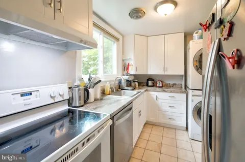 a kitchen with stainless steel appliances granite countertop a sink a stove and a refrigerator