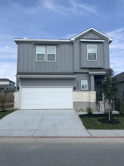 Traditional-style house with board and batten siding, a garage, concrete driveway, and stone siding