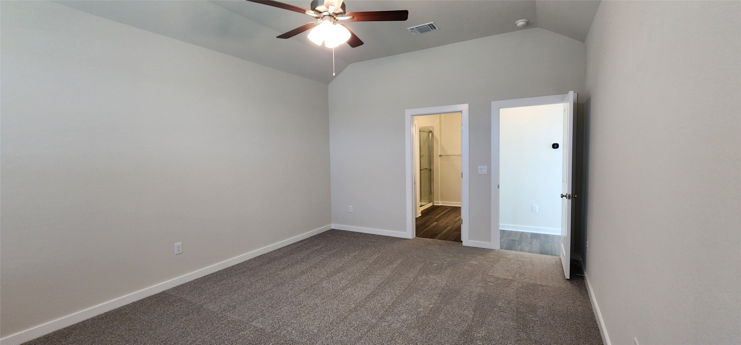 2240 Delano Drive Leander, TX 78641 - Photo 10 of 32 Empty room featuring dark colored carpet, vaulted ceiling, and ceiling fan