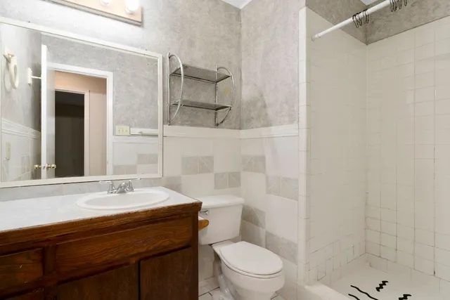 a bathroom with a sink a toilet and shower