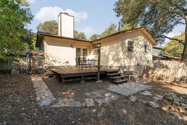 a backyard of a house with barbeque oven table and chairs