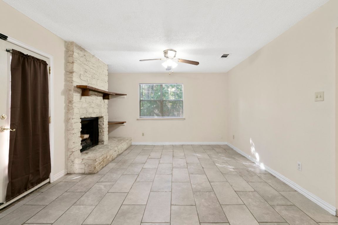 7703 Peaceful Hill Lane, Unit B Austin, TX 78745 - Photo 7 of 22 an empty room with windows and fireplace