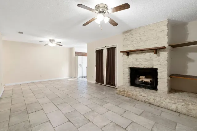 a view of a livingroom with a fireplace and a ceiling fan