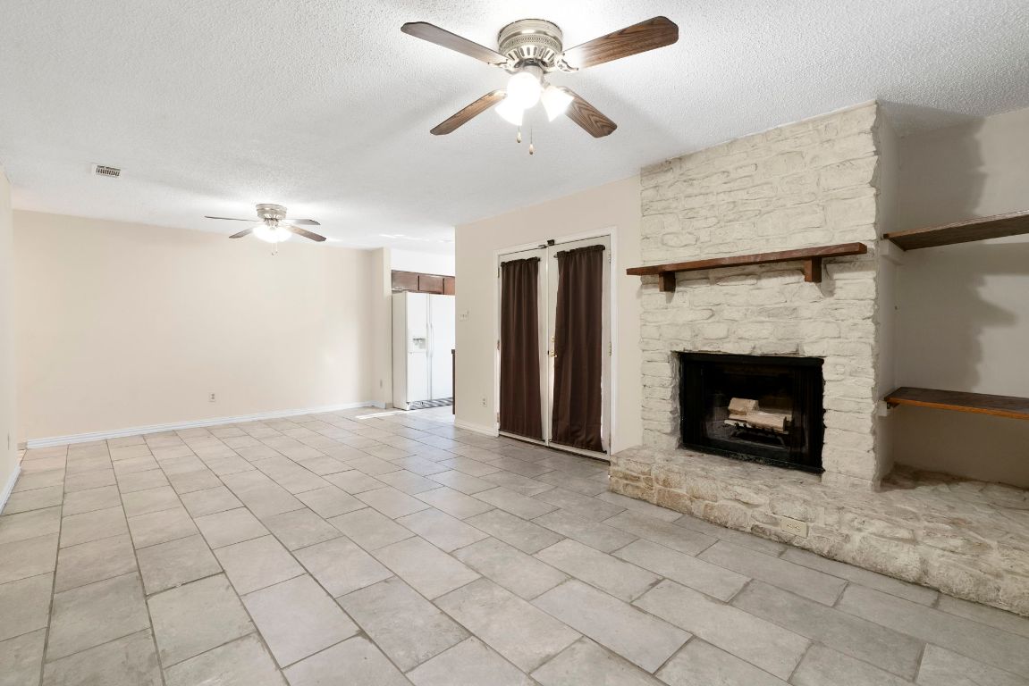 7703 Peaceful Hill Lane, Unit B Austin, TX 78745 - Photo 8 of 22 a view of a livingroom with a fireplace and a ceiling fan