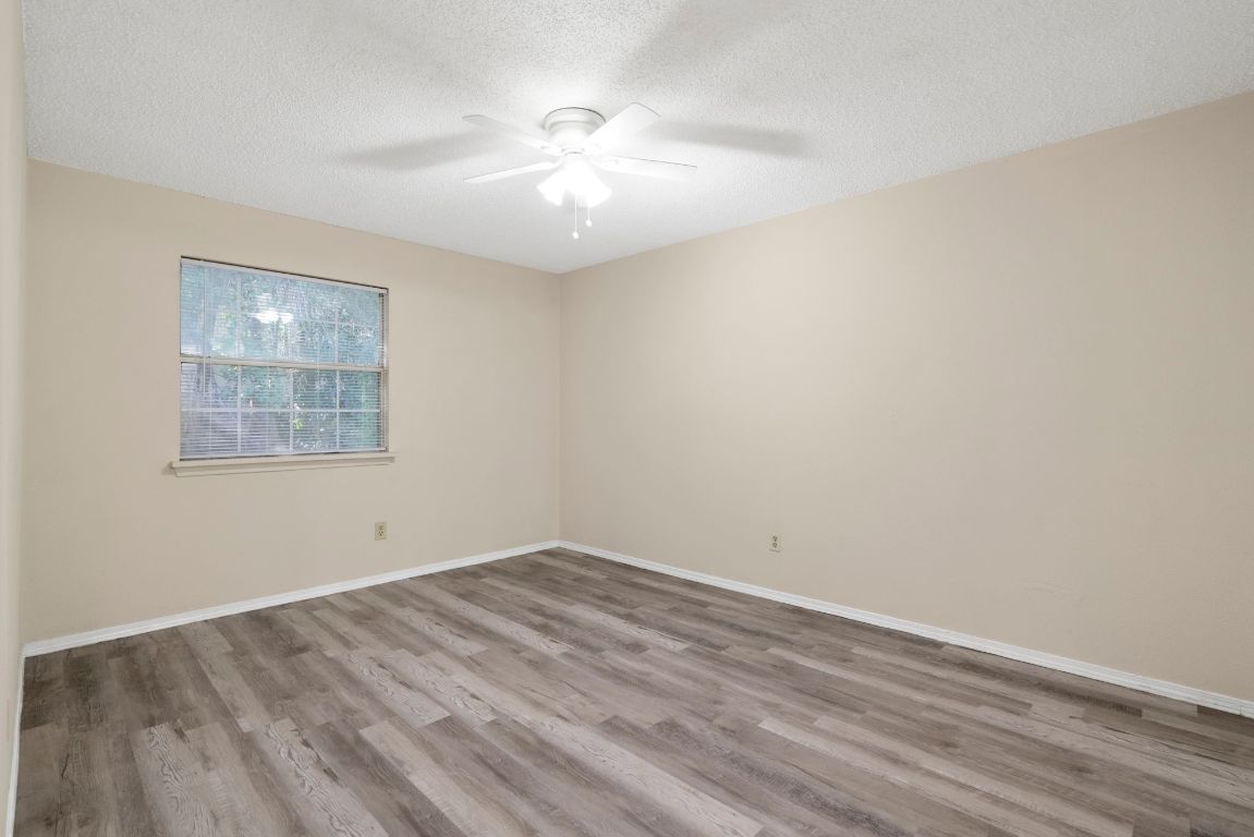 7703 Peaceful Hill Lane, Unit B Austin, TX 78745 - Photo 10 of 22 wooden floor in an empty room with a window