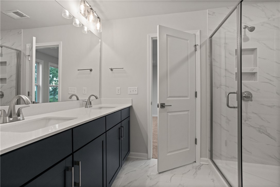 629 Sweetspire Trail, Unit 149 Seneca, SC 29678 - Photo 21 of 30 A spacious primary bathroom boasts a dual-sink vanity and a walk-in shower with elegant tilework.