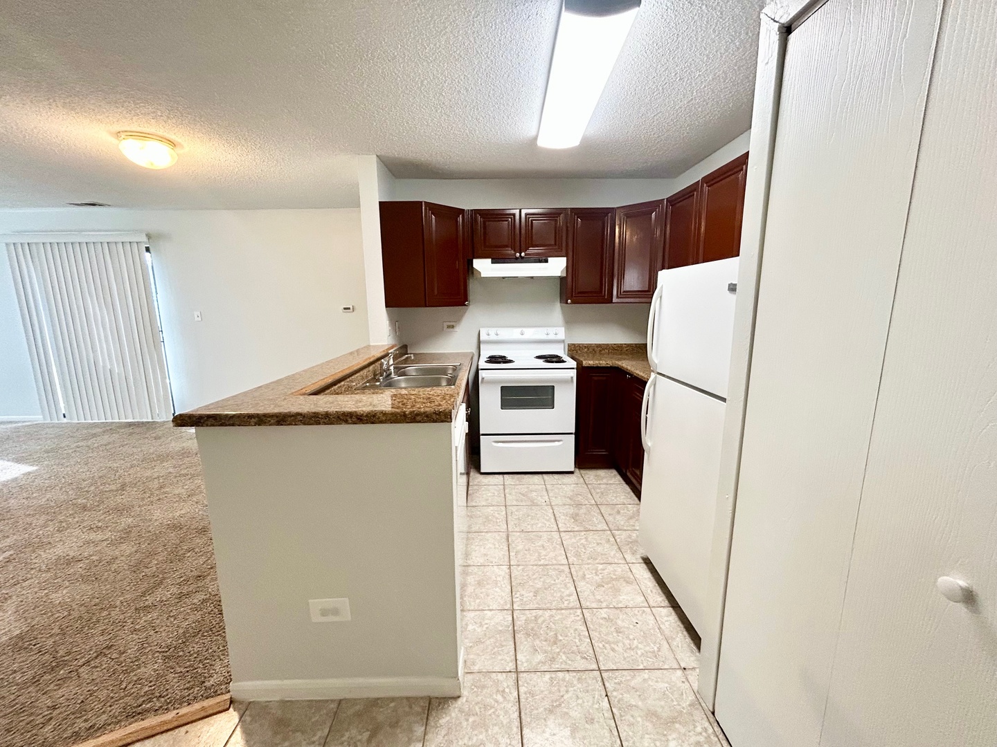 2068 North Rand Road, Unit 109 Palatine, IL 60074 - Photo 2 of 9 a kitchen with a refrigerator and white cabinets